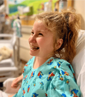 Ella smiling in a hospital gown
