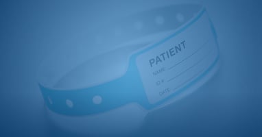 Close-up of a hospital patient identification wristband on a metal surface