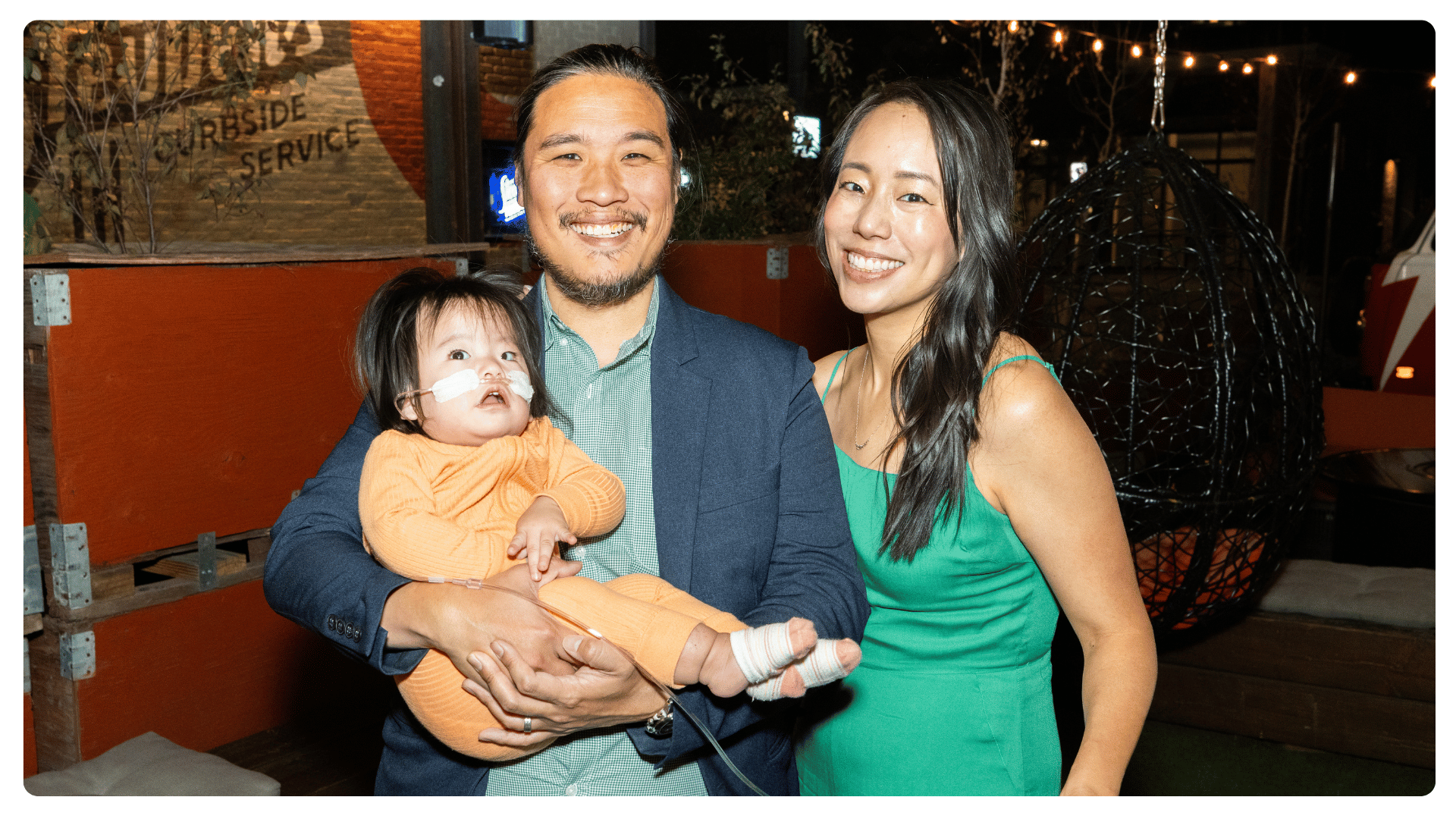 Family of three smiling together at an FPWR conference evening event.
