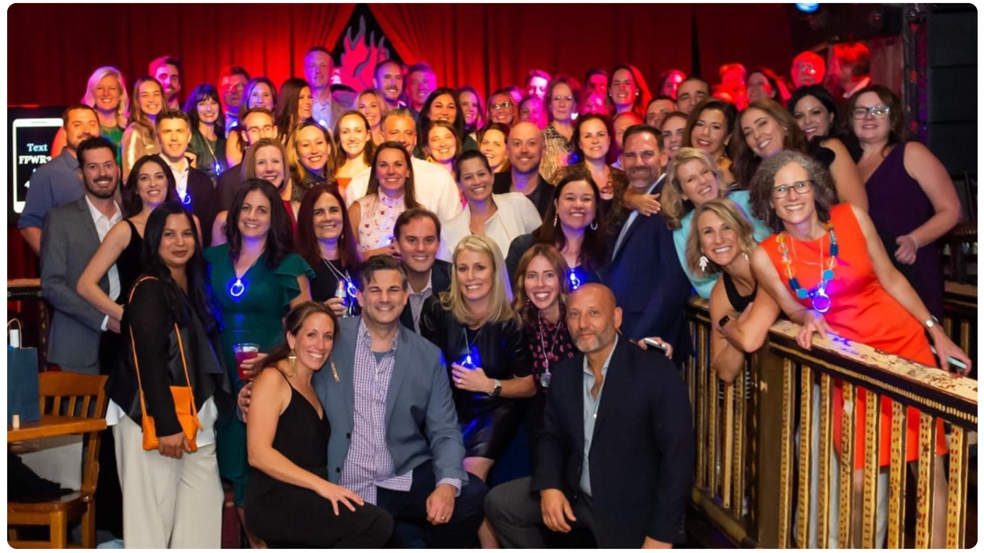 Group of FPWR conference attendees posing together at an evening reception.
