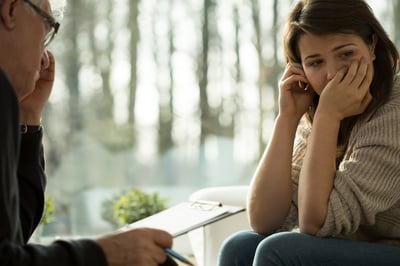 Young depressed woman taking advice from her psychologist