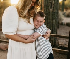 A mother holds her child in a quiet moment, reflecting the emotional care involved in raising a child with Prader-Willi syndrome.